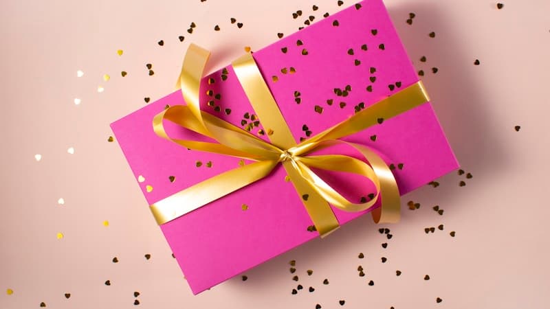 Smiling mascot with gift boxes on red background